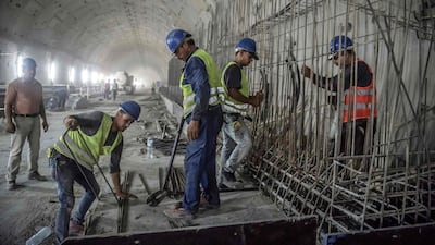 Labourers set up and fix a steel mesh. AFP