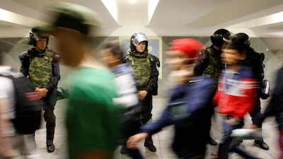 People pass by Interior Ministry members in an underground walkway before a morning prayer, in Moscow, Russia, July 5, 2016. Reuters