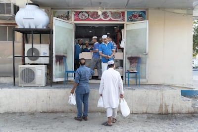 Customers pick up orders of north and south Indian snacks at Ashibilia Restaurant in Al Quoz, Dubai. Antonie Robertson / The National