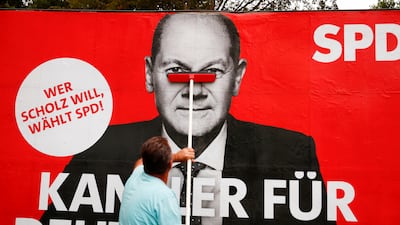 A poster of Olaf Scholz is placed on a board in Bonn. Photo: Reuters