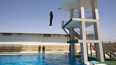 Several women, including non-swimmers, were asked to jump into a pool as a show of courage during the training exercise. They dived in full uniform, including boots, and one had to be pulled out by a lifeguard. Ahmad Gharabli / AFP