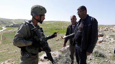 An Israeli soldier argues with Palestinians as an Israeli army bulldozer closes roads leading to Palestinian villages near the West Bank city of Yatta, south of Hebron. According to local media sources, Israeli troops raided the West Bank city of Yatta and blocked several roads in the area. EPA