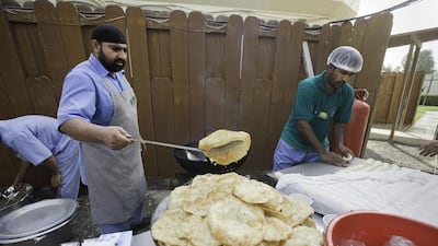 Cooks prepare meals outside the Pakistan consulate.