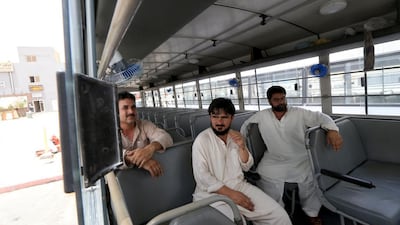 Workers’ bus drivers, from right, Jehangir Khan, Shakir Lachi and Mohammed Afridi talk about the dangers they face daily on the roads in their job. Ravindranath K / The National