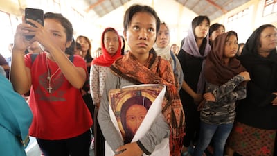 Acehnese Christian devotees hold a Jesus Christ portrait, during a re-enactment of his the crucifixion during Good Friday in Hati Kudus Church, Banda Aceh, Indonesia. EPA