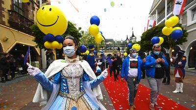 An employee welcomes visitors as they enter Europa Park in Rust. Europa Park is one of the first major theme parks in Germany to reopen its doors to visitors. AFP