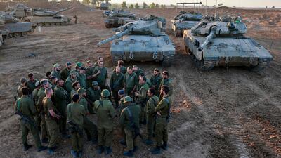 Israeli soldiers gather for a briefing next to tanks on the southern border with the Gaza strip during the temporary truce. AFP