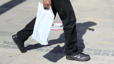 A passer by walks near a safe distance sign in Bur Dubai. Chris Whiteoak / The National