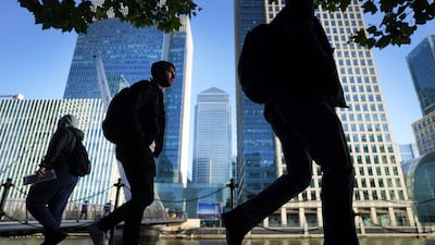 Office workers and commuters walk through London's Canary Wharf. UK government spending is starting to fall as life slowly returns to normal. PA