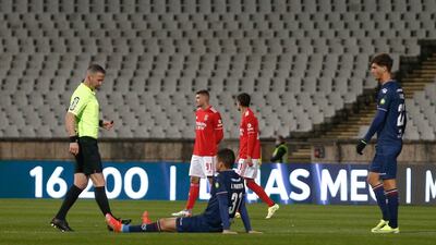 Belenenses's Joao Monteiro lies on the floor injured during the match against Benfica. Belenenses ran out of the minimum number of players, after starting with only nine, due to an outbreak of Covid-19. Followed by three injuries on the pitch that reduced them to six. EPA