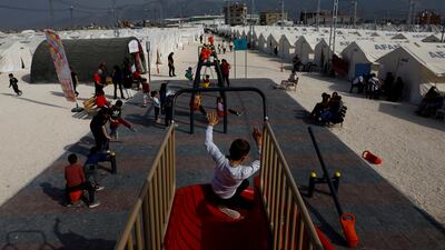 Children play at a playground in the Orhanli tent city following the deadly earthquake in Antakya, Hatay province. Reuters