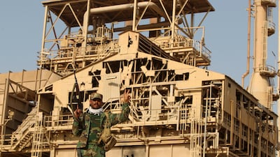 An Iraqi Shiite fighter flashes the victory sign in front of the fertiliser plant in the town of Baiji, north of Tikrit, after Iraqi forces retook the industrial area and several other neighbourhoods from ISIS, in October 2015. AFP