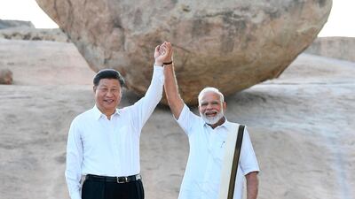 The Indian and Chinese leaders raise hands at Arjuna's Penance in Mamallapuram. AP