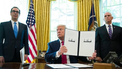 President Donald Trump holds up a signed executive order to increase sanctions on Iran, flanked by Treasury Secretary Steve Mnuchin, left, and Vice President Mike Pence, in the Oval Office of the White House. AP/Alex Brandon