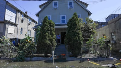 A person cleans the porch of their house after a night of high winds and rain from the remnants of Hurricane Ida on September 2, 2021 in Mamaroneck, New York. AFP
