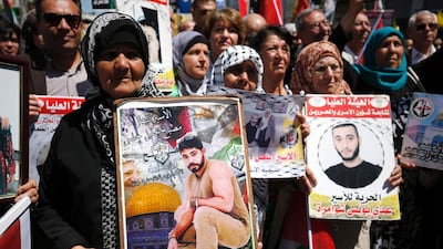 Protesters hold portraits of Palestinian prisoners during a rally in the West Bank city of Ramallah to show their support to Palestinians detained in Israeli jails after hundred of them launched a hunger strike on April 17, 2017. Abbas Momani/AFP