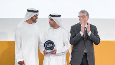 Sheikh Mohamed bin Zayed presents a reach award to Abdullah Khalifa Al Ghafli during the Global Health Forum. Seen with Bill Gates. Hamad Al Kaabi / Crown Prince Court - Abu Dhabi