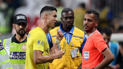 Al Nassr's Cristiano Ronaldo speaks to the fourth official as he leaves the pitch at half-time. Reuters