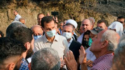 Syrian President Bashar Al Assad (centre), wearing a mask to help prevent the spread of the coronavirus, speaks with people during his visit to the coastal province of Latakia, Syria. AP