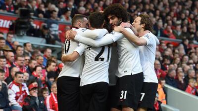 Manchester United players celebrate with Juan Mata after his opening goal for the team on Sunday against Liverpool. Paul Ellis / AFP