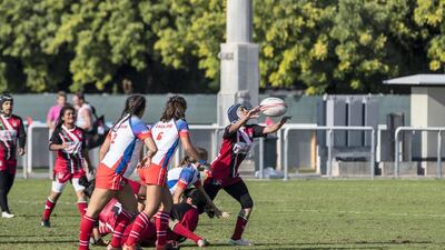 An Al Maha School girls player tries to gather the ball.