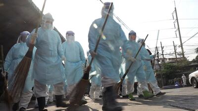 Workers walk through Samut Sakhon Shrimp Center as they disinfect the market in Samut Sakhon, Thailand. AFP