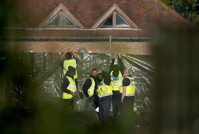 Security staff work to cover the view of people thought to be migrants at the Manston immigration short-term holding facility. PA