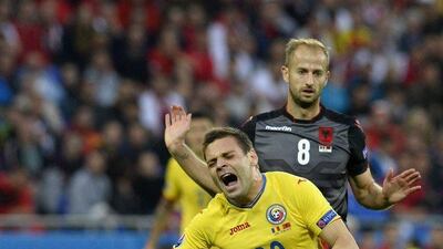 Adrian Popa, centre, of Romania is tackled during the Euro 2016 Group A match against Albania at Stade de Lyon in Lyon, France, 19 June 2016. CJ Gunther / EPA