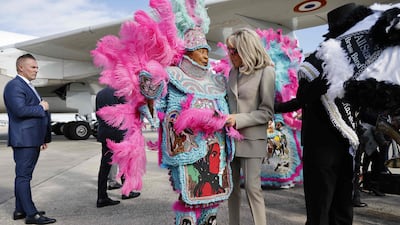 Ms Macron is welcomed on her arrival by a member of a Mardi Gras Indian tribe. AFP