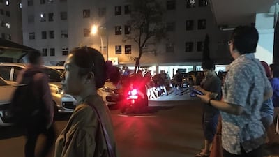 Resident stand outside an apartment block. AFP