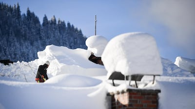Workers clear a roof covered with snow in Gerold. EPA