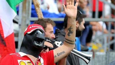 A Ferrari fan with a horse mask watches the action during qualifying at Monza in 2018. Getty