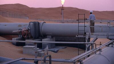 A worker stands at a pipeline, watching a flare stack at the Saudi Aramco complex facilities at Shaybah, Saudi Arabia. The Saudi oil minister said Opec cuts are helping the oil market.