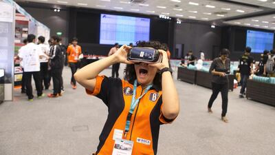 At the F1 in Schools final on Tuesday, Liza Zimmermann, 18, of Peregrine Racing team from Raha International, puts on a virtual reality device allowing her to look around the Moon’s surface. The event promotes science subjects in schools. Reem Mohammed / The National
