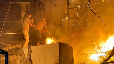 Residents try to put out a fire after an Israeli attack on a tent camp for displaced Palestinians in Deir Al Balah in the central Gaza Strip. Reuters