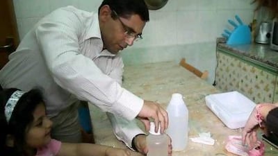 Muhammad Salah collects tap water samples from his home in Al Ain that will be tested for bacteria and safety.