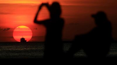 A group of friends are silhouetted as they take a photo while watching the sun set along the coast of Manila bay in Metro Manila, Philippines on January 27, 2017. Romeo Ranoco / Reuters