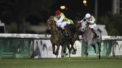 Rakha, left, ridden by Silvestre de Sousa, and Sha’Red, ridden by James Doyle, finished in a dead heat in the Al Ruwais sprint at the Abu Dhabi Equestrian Club on Sunday night. Lee Hoagland / The National