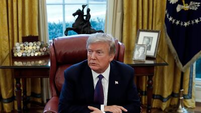 US president Donald Trump sits at his desk in the Oval Office of the White House on January 23, 2018. Carolyn Kaster / AP