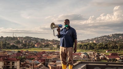 Gonzaga Yiga, a 49-year-old community chairperson, appeals to residents through a speaker from the tallest building of the area, in Kampala, Uganda. AFP