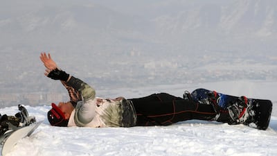 An Afghan snowboarder takes a break during a practice session on a snow-covered hilltop in Kabul. EPA