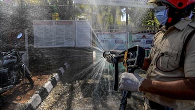 A firefighter disinfects a street near Nizamuddin Markaz Mosque in New Delhi. AFP