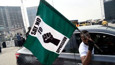 A man carries a national flag bearing the words: 'Say No To Oppression'. AFP
