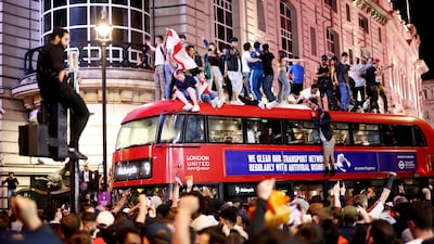 England fans celebrate on top of a bus at Piccadilly Circus.