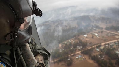 Leading seaman aircrew Brendan Menz looking out the door of HMAS Choules' MRH-90 Maritime Support Helicopter over Southern New South Wales, Australia. Australian Department of Defence/EPA