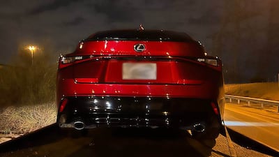 An impounded car is driven to storage on the back of a flatbed lorry. Photo: Dubai Police