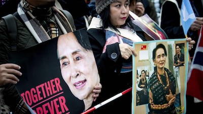TOPSHOT - Protesters in support of Myanmar's State Counsellor Aung San Suu Kyi hold pictures in front of the Peace Palace of The Hague on December 11, 2019, following Aung San Suu Kyi's second day of hearing on the Rohingya genocide case. Aung San Suu Kyi is set to speak out in Myanmar's defence at the UN's top court on December 11, 2019, a day after the former democracy icon was urged to "stop the genocide" against Rohingya Muslims. Once hailed internationally for her defiance of Myanmar's junta, the Nobel peace laureate will this time be on the side of the southeast Asian nation's military when she takes the stand at the International Court of Justice. - Netherlands OUT / AFP / ANP / Koen Van WEEL