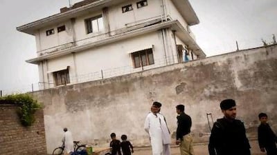Pakistani police and locals gather outside the compound where Osama bin Laden was killed during Operation Geronimo in May 2011. Warrick Page / Getty Images