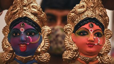 A shopkeeper displays idols representing deities and characters from Hindu mythology in Chennai. AFP