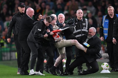 Security staff tackle a protestor wearing a Palestine flag who ran onto the pitch during the Nations League match between Ireland and Austria in Dublin. Getty Images